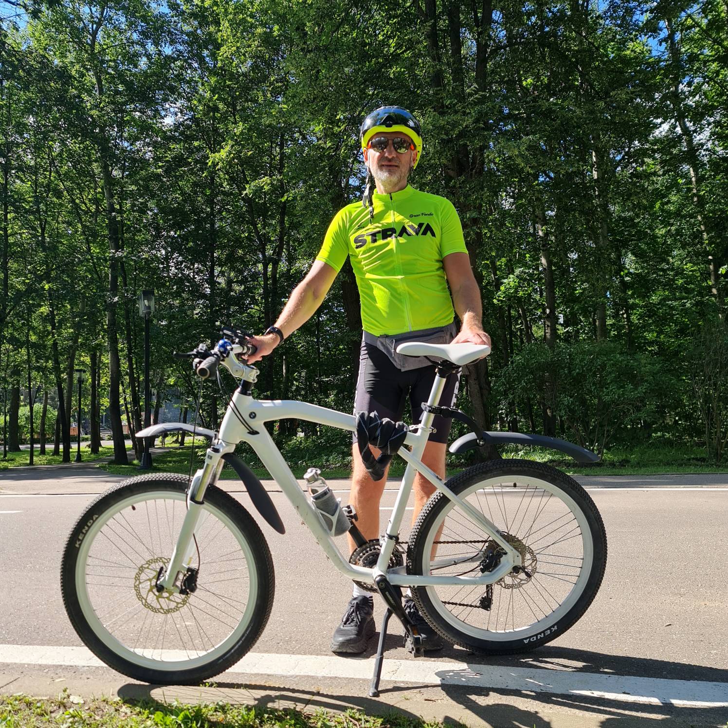 Vasily with his bicycle on a tree-lined path